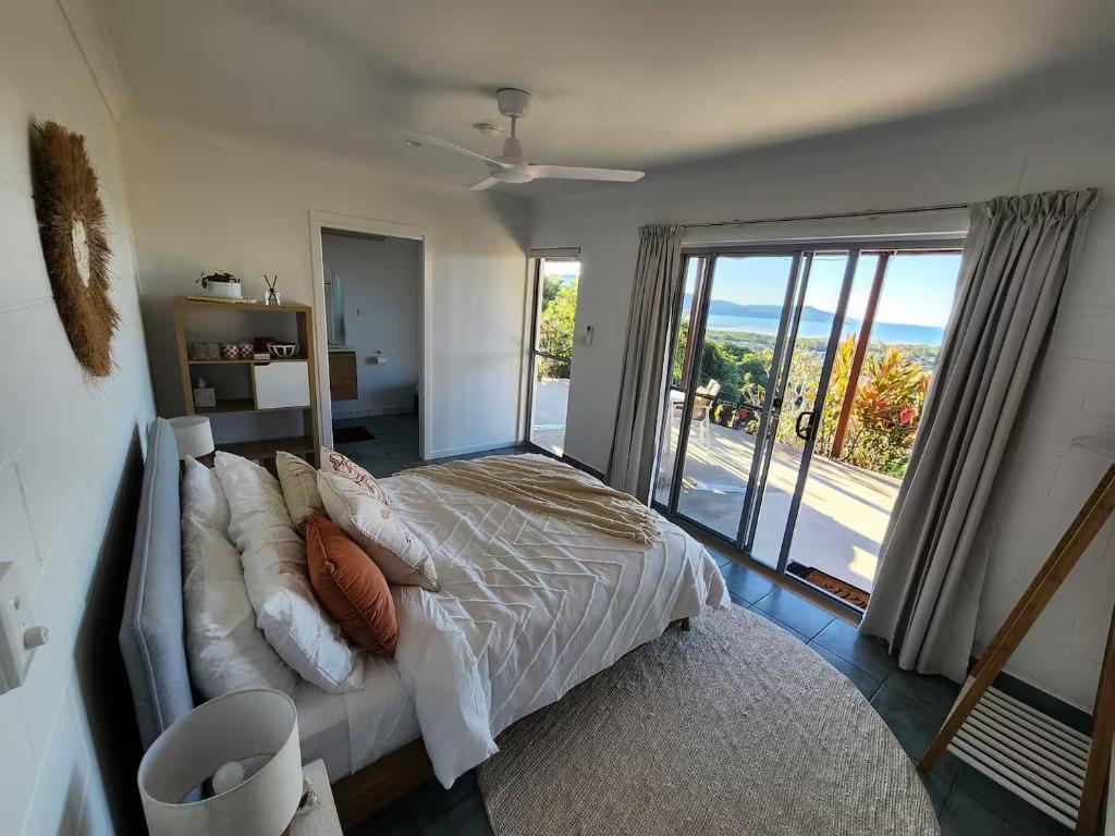 a bedroom with a bed and a large window at Ocean View Oasis in Cannonvale