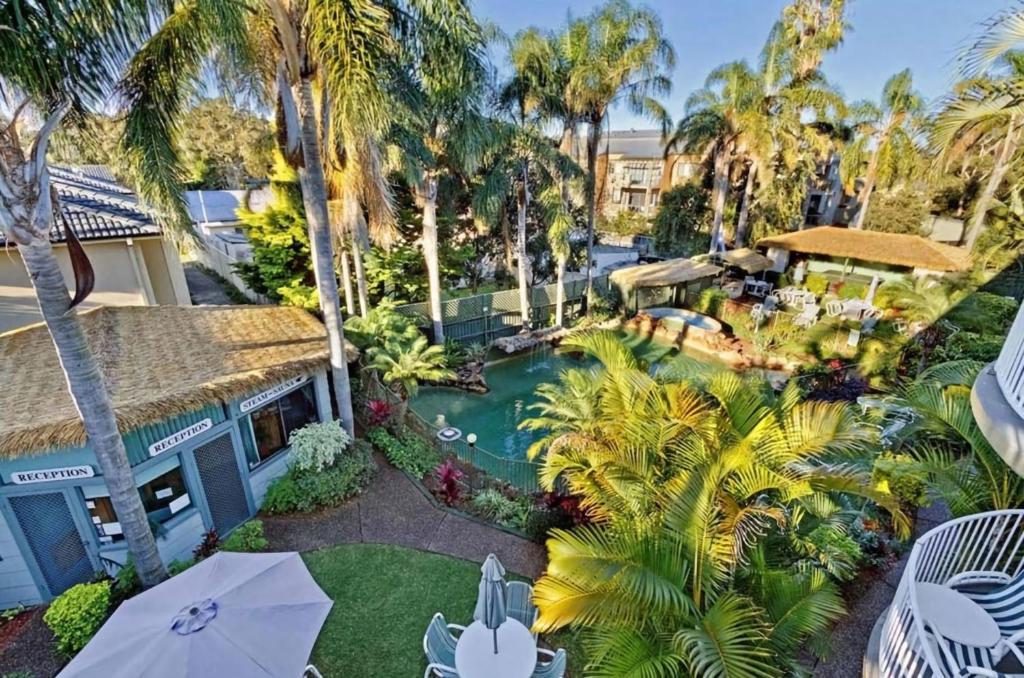 an aerial view of a resort with a pool and palm trees at Allamanda Unit 22 in Long Jetty