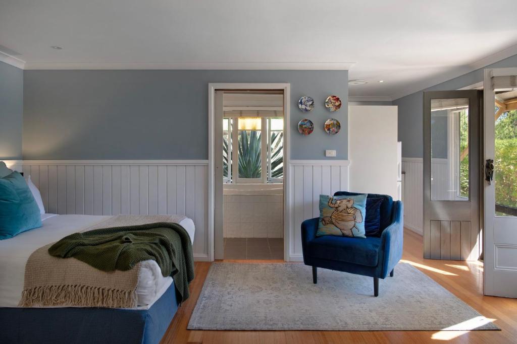 a bedroom with a bed and a blue chair at Oscars in Hepburn Springs