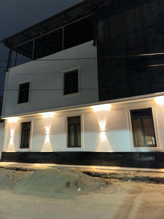 a white building with lights on the side of it at Oftob in Bukhara