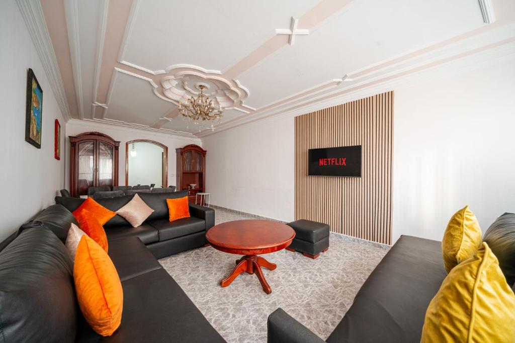 a living room with a black couch and a table at Spacious Apartment 1 min from Beach in Tangier