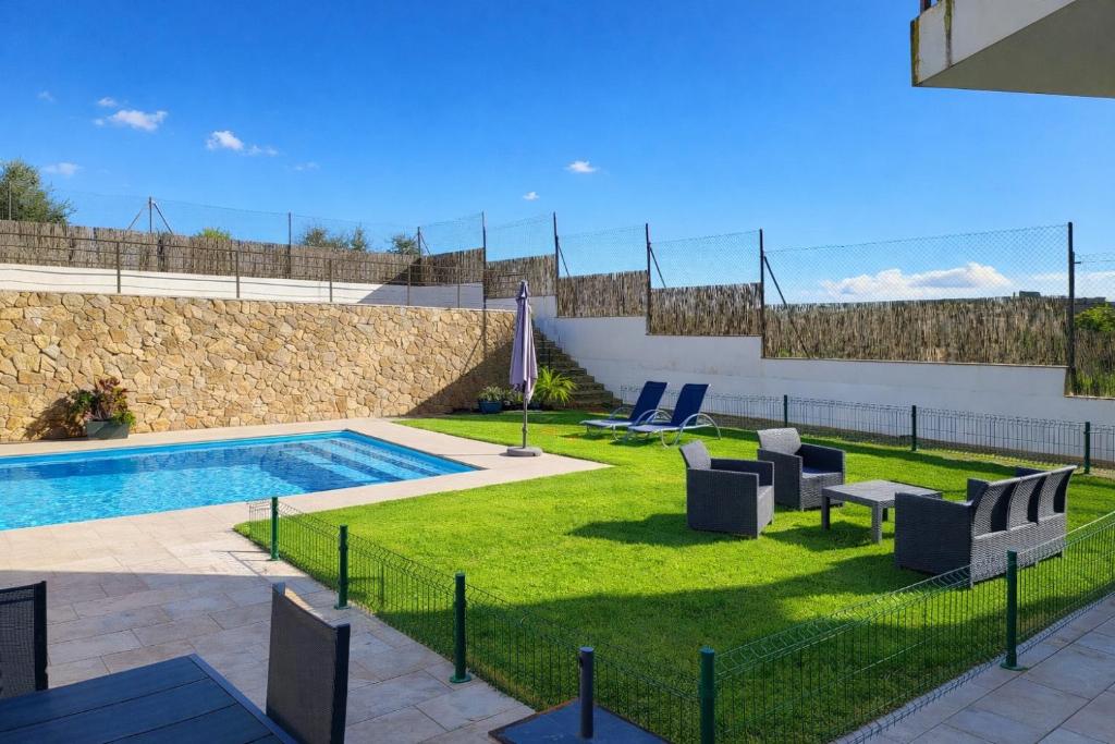 a backyard with a swimming pool and a lawn with chairs at Casa Solaria Córdoba in Guadalcázar