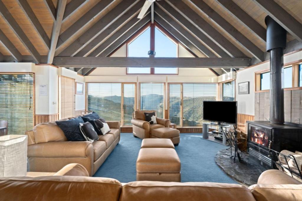 a large living room with couches and a fireplace at Cobungra Chalet in Mount Hotham