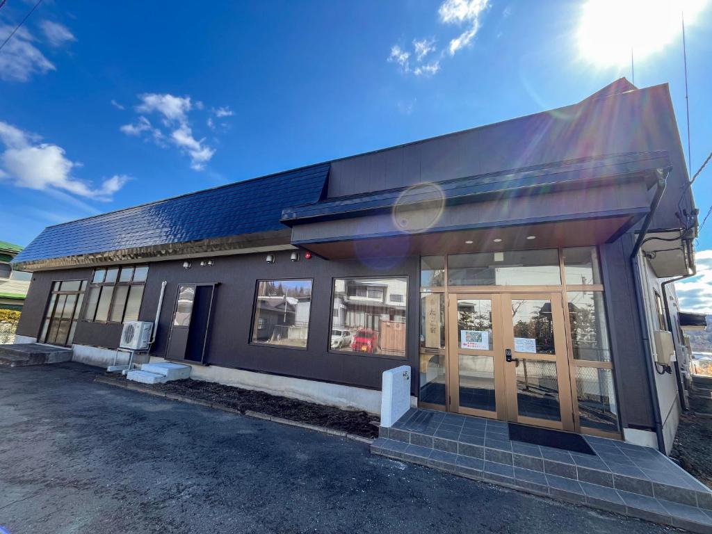 a building with glass doors in a parking lot at たっこ宿 in Takko