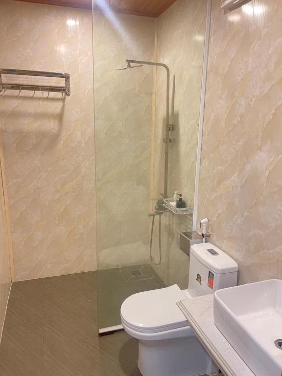 a bathroom with a shower and a toilet and a sink at Huy Hùng Cô Tô in Nam Cap