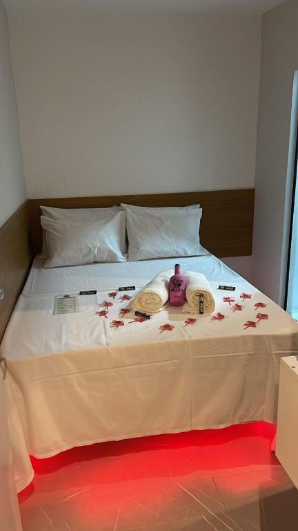 a white bed with flowers on top of it at Hotel Love Augustta in São Paulo