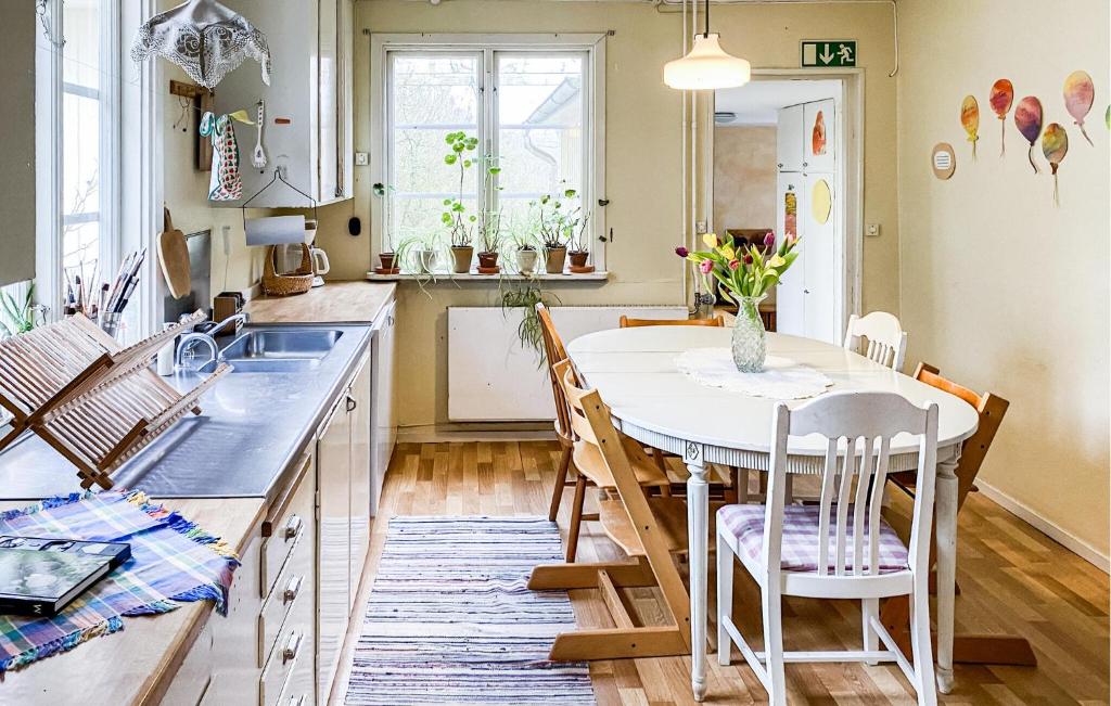 a kitchen with a table and chairs and a sink at 2 Bedroom Nice Home In Glömminge in Glömminge