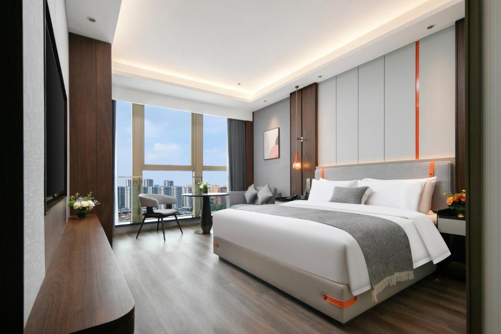 a bedroom with a large white bed and a large window at Grand Madison Hotel Hangzhou in Hangzhou