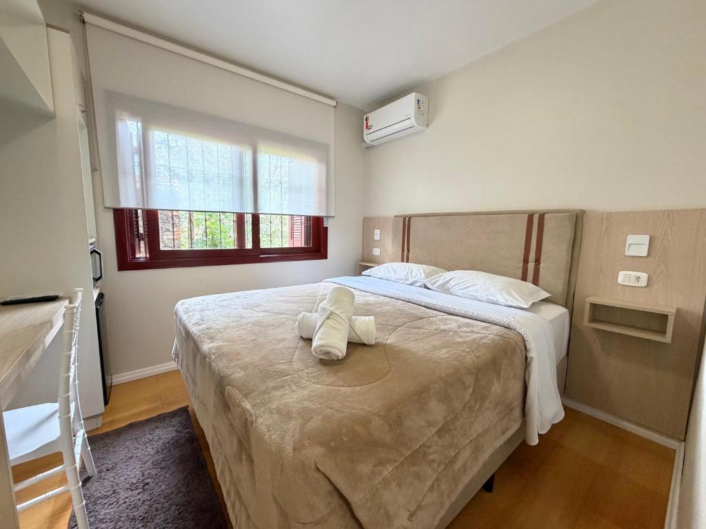 a bedroom with a bed with two towels on it at Pousada Cores De Outono in Canela