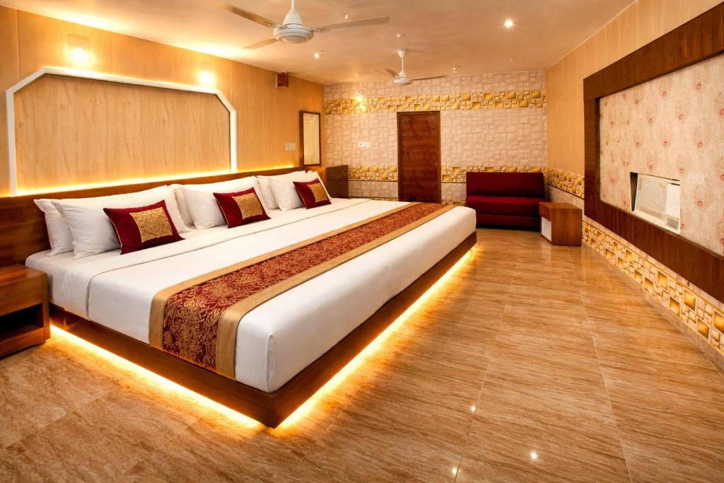 a bedroom with a large bed in a room at Tripathi's Rampath Inn Ayodhya in Ayodhya