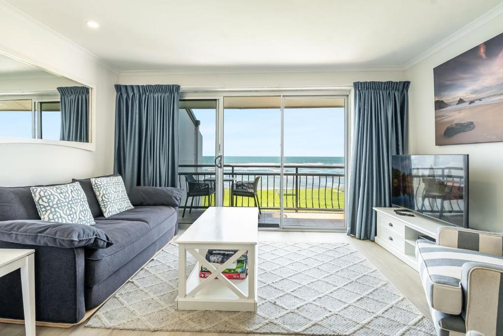 a living room with a couch and a tv at Apartment 9T in Lennox Head