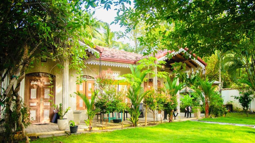 a house with trees in front of it at Angelica Villa in Bentota