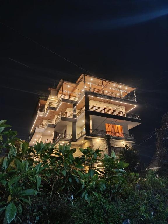 a tall building with lights on it at night at Hotel Kaavi in Pokhara