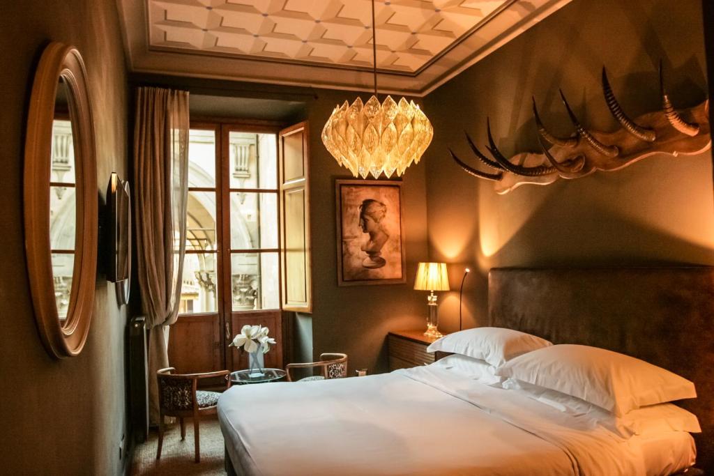 a bedroom with a bed with a antlers on the wall at Porcellino Gallery Art Boutique BB in Florence