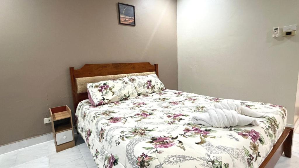 a bedroom with a bed with a floral bedspread at Collection O Southern Star Resort Pattaya in North Pattaya
