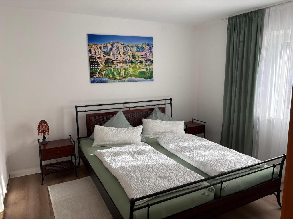 a bed in a bedroom with a picture on the wall at Ferienwohnung Tante Betty in Essing