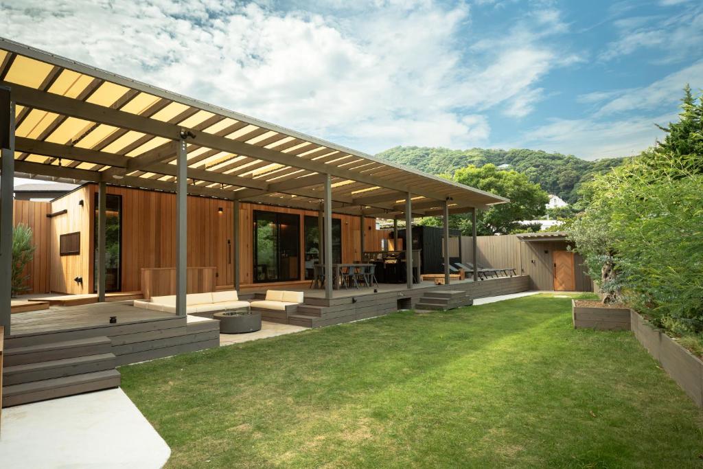 an outdoor patio with a pergola and grass at Tiny Base The Irita-hama in Shimoda