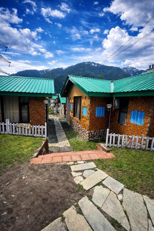 a couple of buildings with green roofs at Aura Montane luxury cottages in Manāli