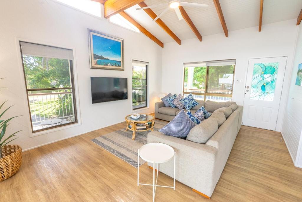 a living room with a couch and a table at Amity Treetops - Prime Location - Sleeps 7 in Amity Point