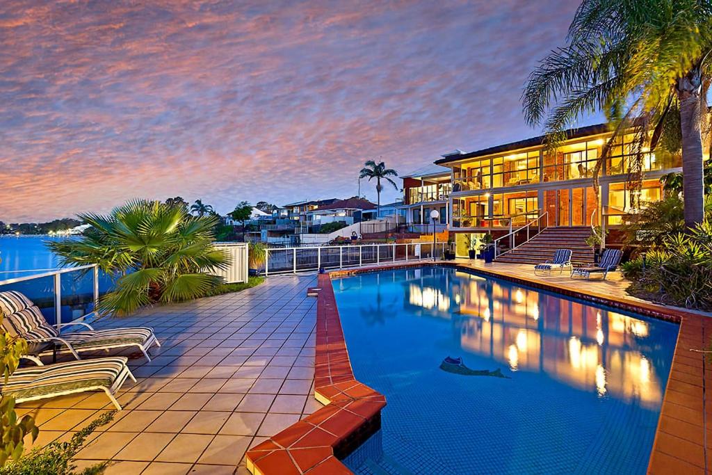 a swimming pool in front of a building at Toukley Waterfront House in Toukley