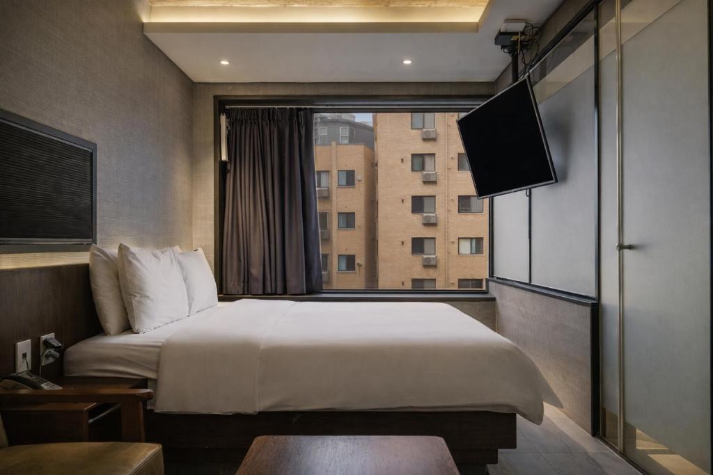 a hotel room with a bed and a window at Zenith Hotel Bupyeong in Incheon
