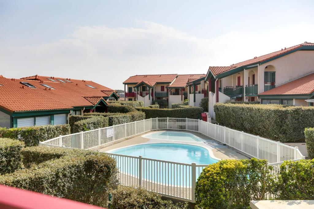 a swimming pool in a yard with houses at Appartement Santocha in Capbreton