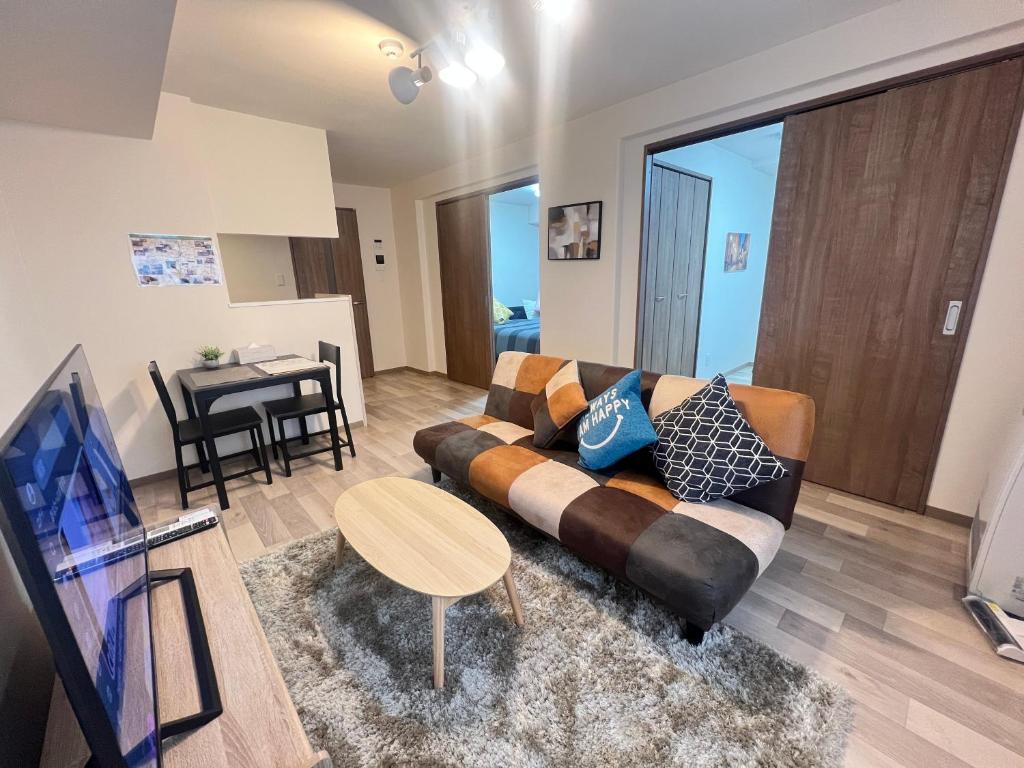 a living room with a couch and a table at ホロムア澄川 in Sapporo