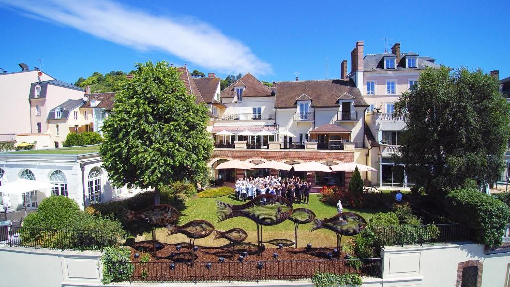 un grupo de personas de pie frente a un gran edificio en La Côte Saint Jacques, en Joigny