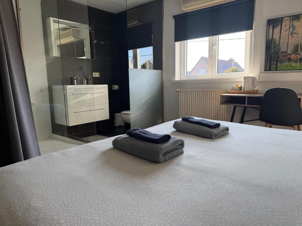 a bedroom with a bed with two towels on it at Guest house Time to Escape in Meise