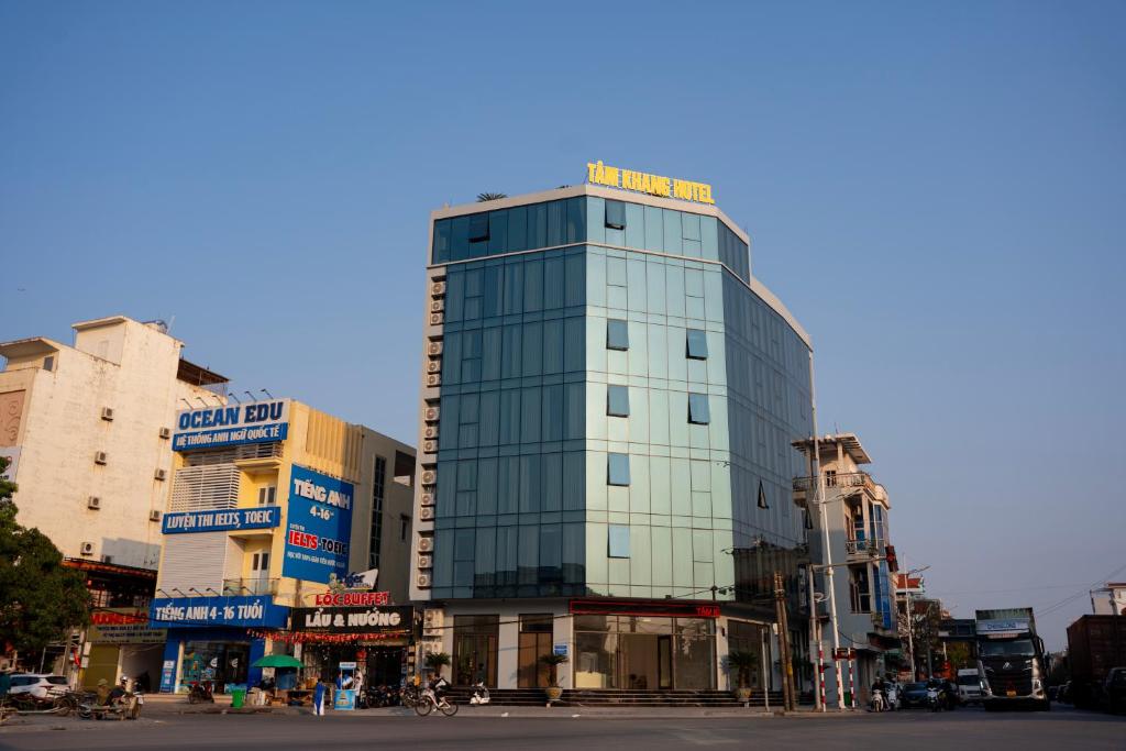 a tall glass building on a city street at Tâm Khang Hotel in Móng Cái