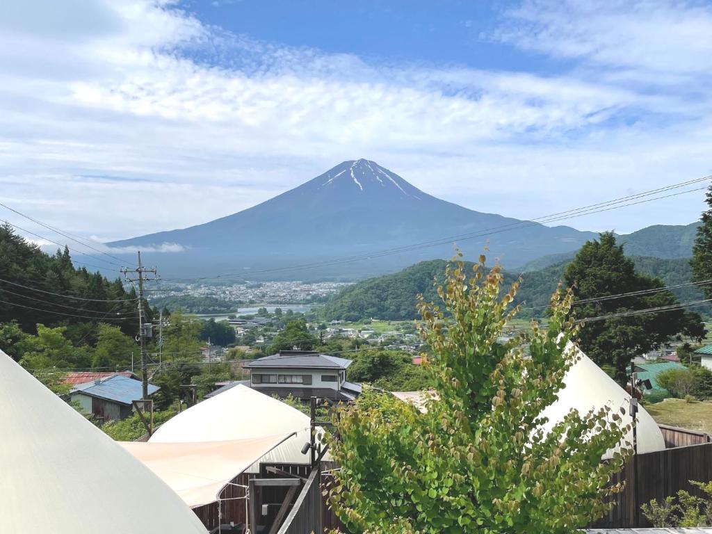 a mountain in the distance with a town and tents at Dot Glamping 富士山 in Fujikawaguchiko