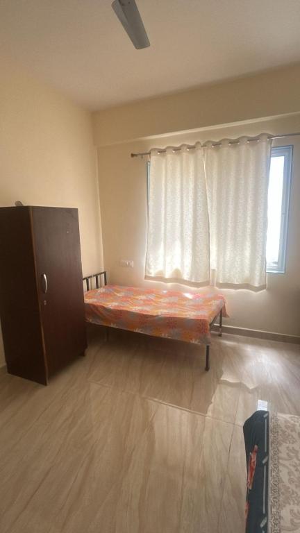 a room with a bed in front of a window at Peaceful & hygienic stay , Ideal for working professionals, Great for solo female travelers in Pune