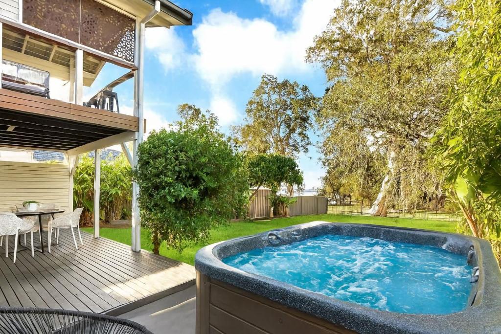 a hot tub on the deck of a house at Natuna Lakeside Retreat in Budgewoi