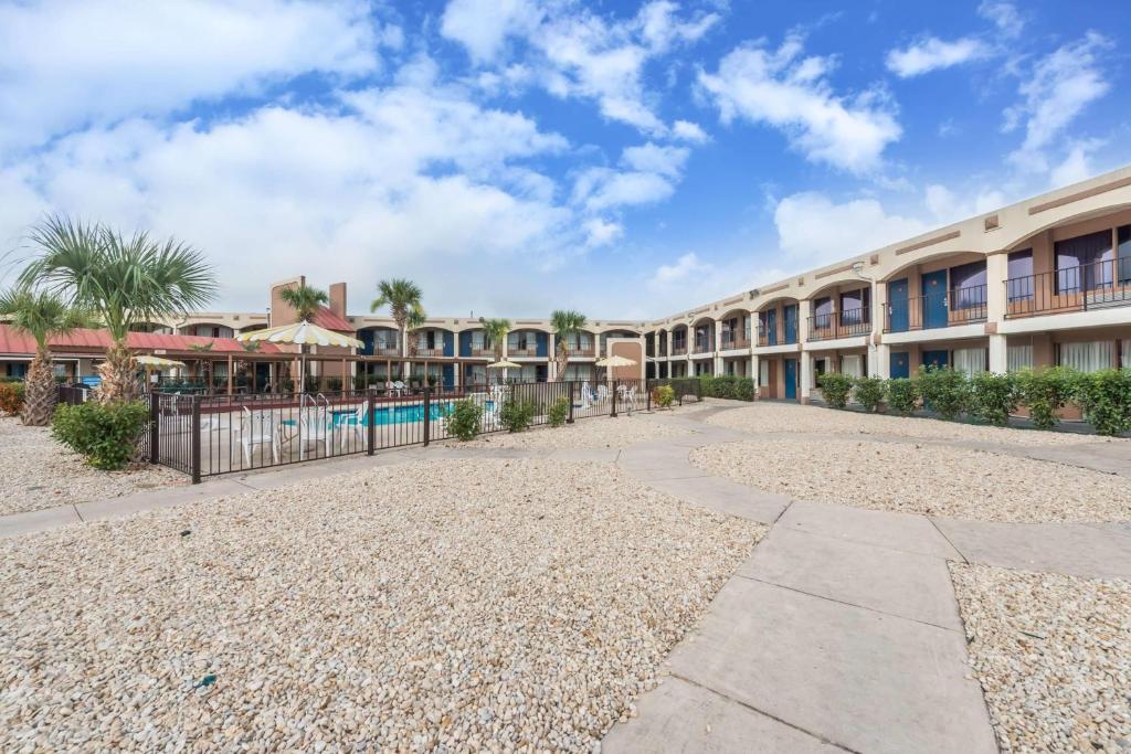 a building with a pool and a resort at Days Inn by Wyndham San Antonio Splashtown/ATT Center in San Antonio