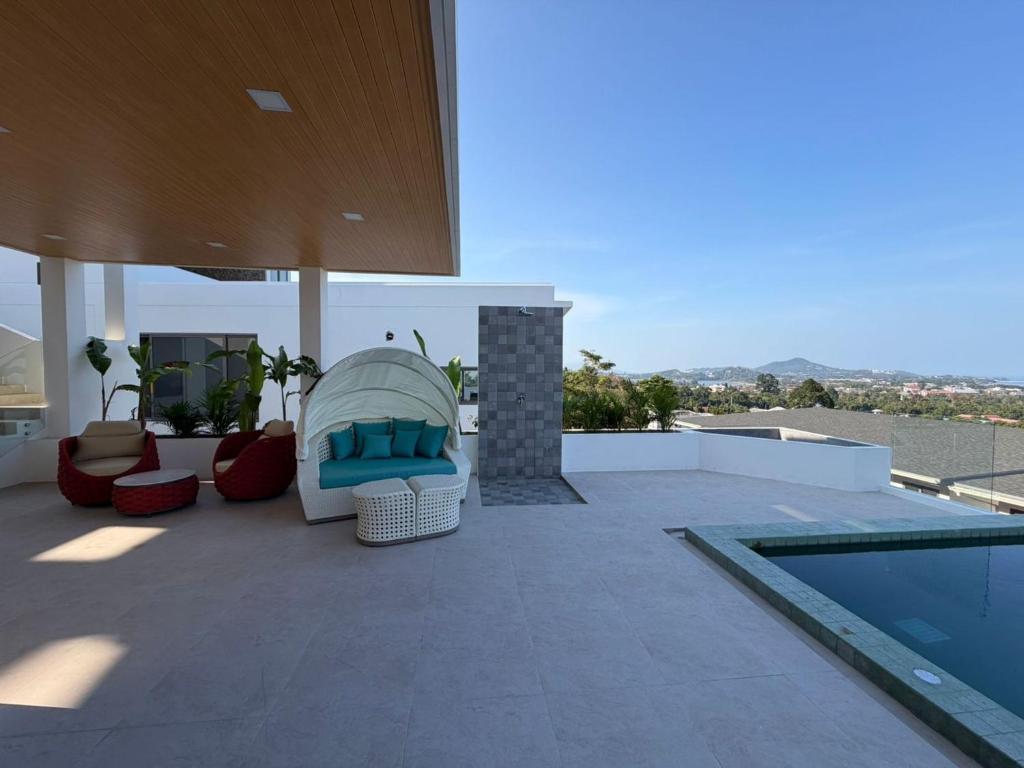 a patio with a chair next to a swimming pool at Luxurious Villa with Private Indoor Pool in Bophut