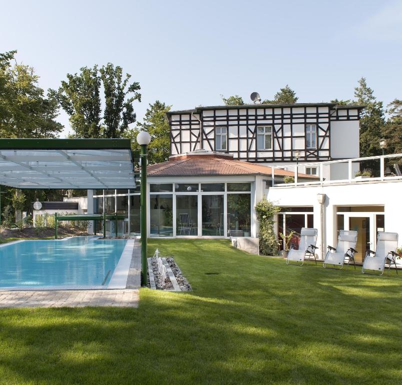 ein Haus mit Swimmingpool im Garten in der Unterkunft Best Western Plus Ostseehotel Waldschloesschen in Prerow