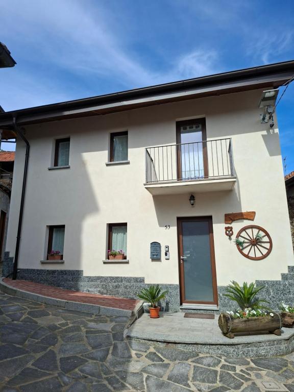 a white house with a balcony and a wheel at La corte in Vezzo