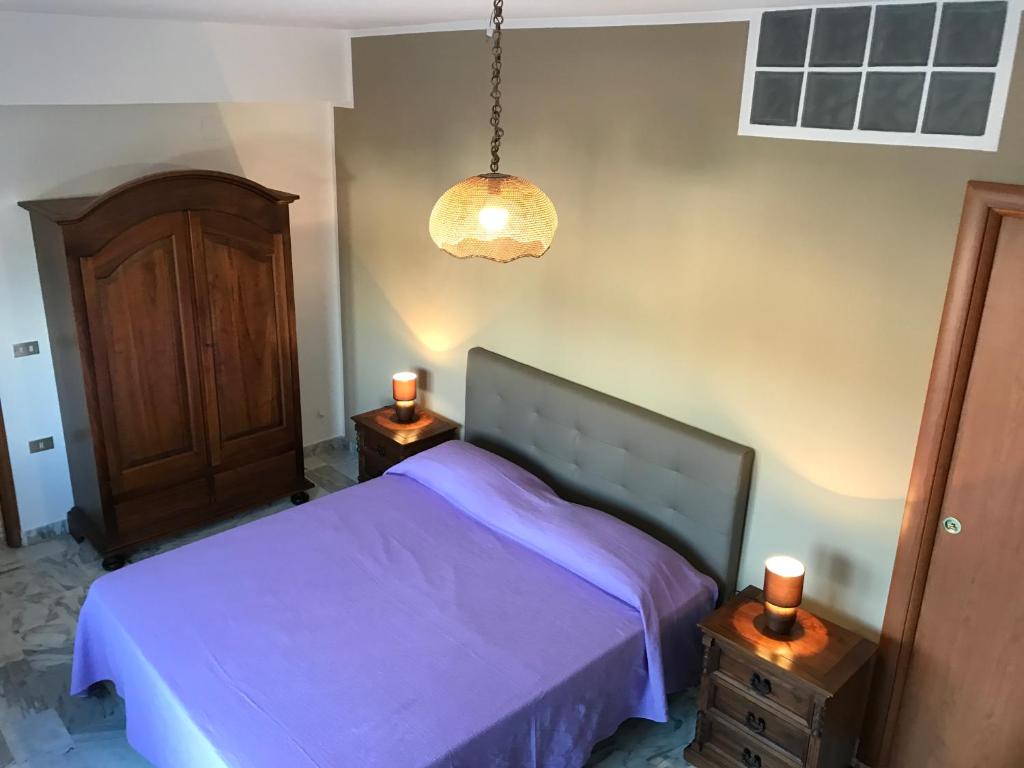 a bedroom with a purple bed and two night stands at Terrazze sul Mare Melito Di Porto Salvo in Melito di Porto Salvo