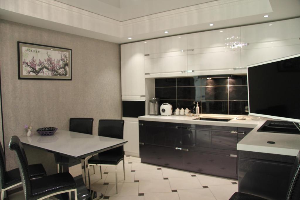 a large kitchen with a table and a counter top at Apartment on Komsomolskaya 295 in Yuzhno-Sakhalinsk