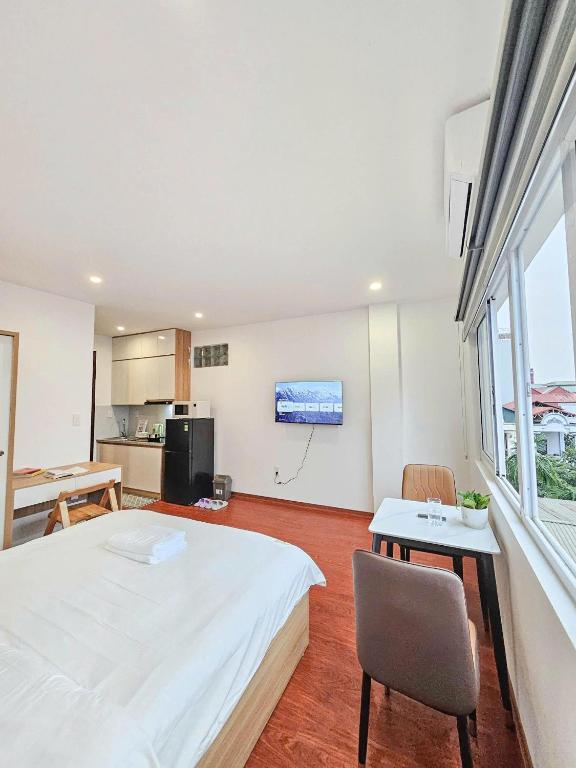 a bedroom with a large white bed and a table at Lakenest 06 - Quiet Place in Hanoi