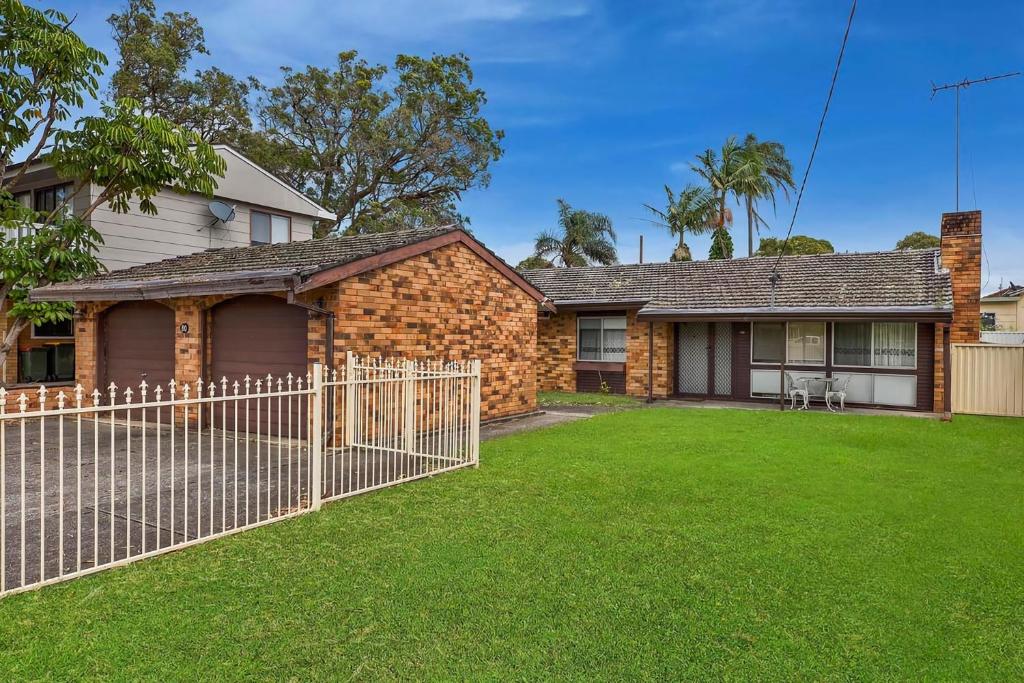 a brick house with a fence in front of a yard at Fravent house in Toukley
