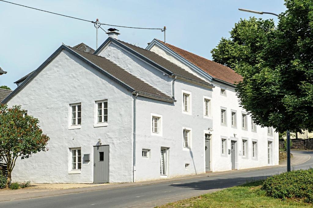 a white building on the side of a street at Nengshof Ferienhaus Ehrenpreis in Wißmannsdorf