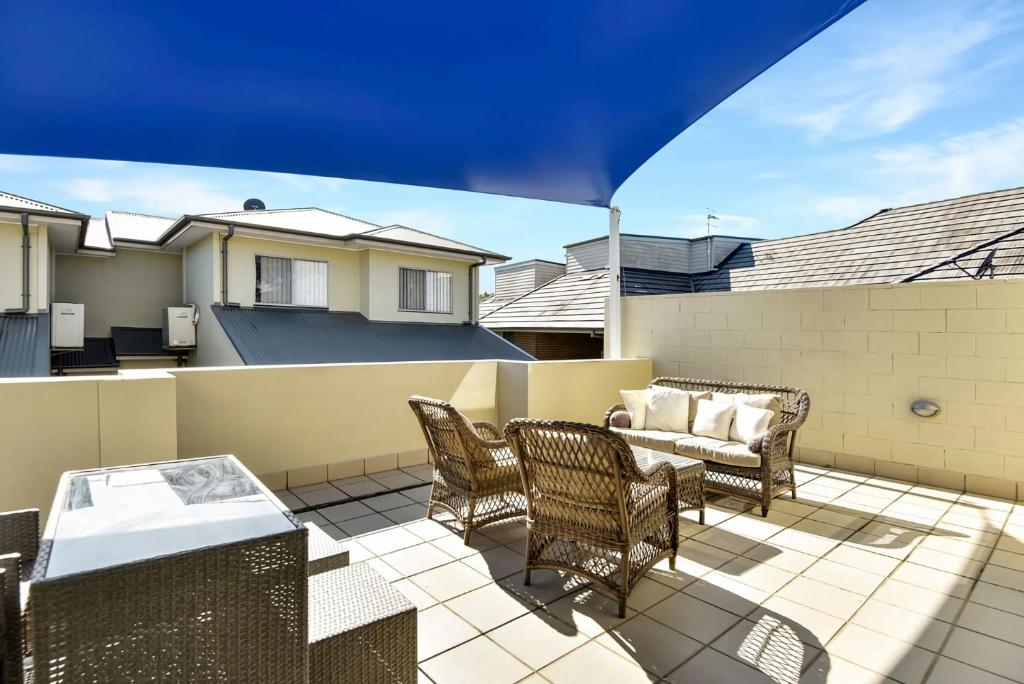 a patio with chairs and a couch on a balcony at The Gallipoli Residence in Long Jetty