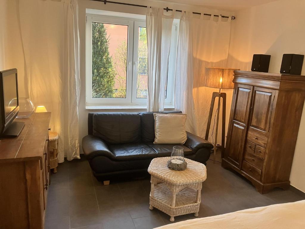 a living room with a leather couch and a window at Ferienwohnung Rolofs in Bad Nenndorf