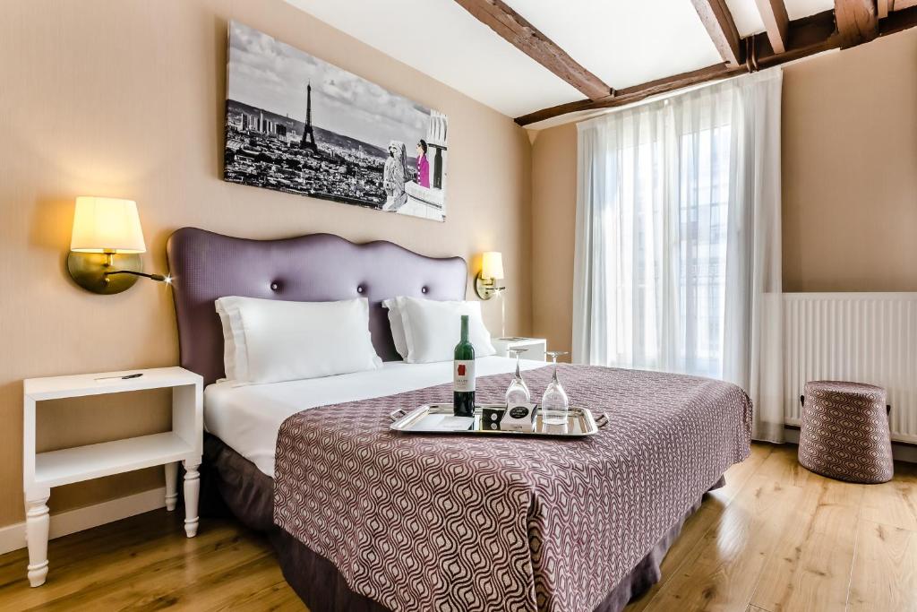 Habitación de hotel con cama con colcha púrpura en Exe Paris centre, en París