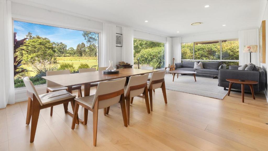 a dining room and living room with a table and chairs at 21 Forever in Pokolbin