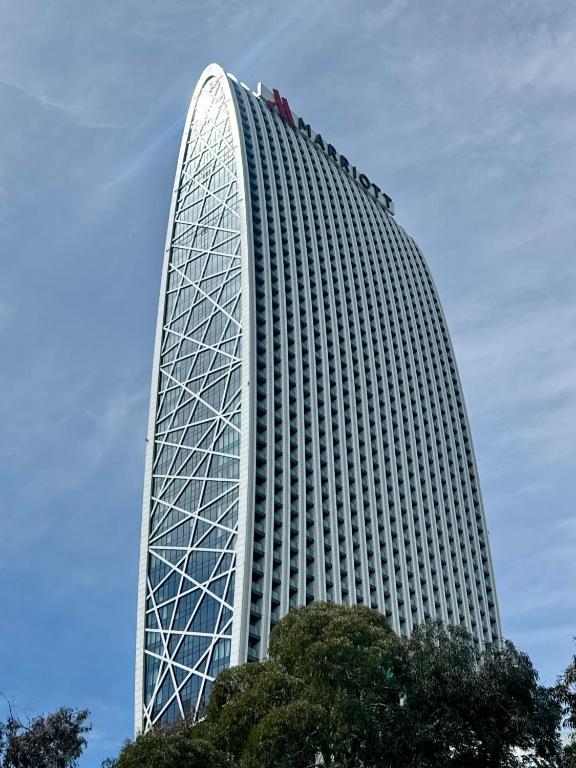 a tall white building with trees in front of it at Apartment with sea View in Batumi