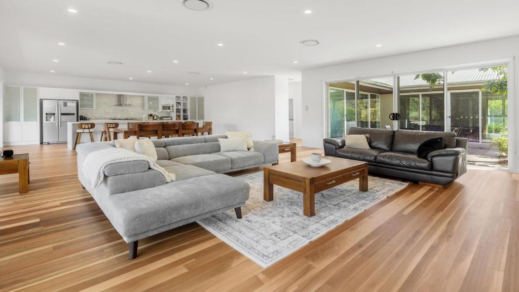 a living room with two couches and a table at Dashaz Dream - The Vintage in Pokolbin