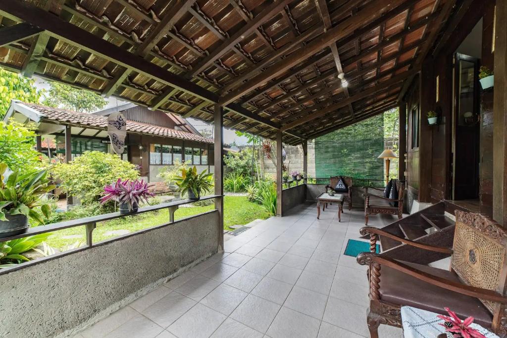 an outdoor patio with benches and plants on a house at Dedaunan Guesthouse in Tlekung