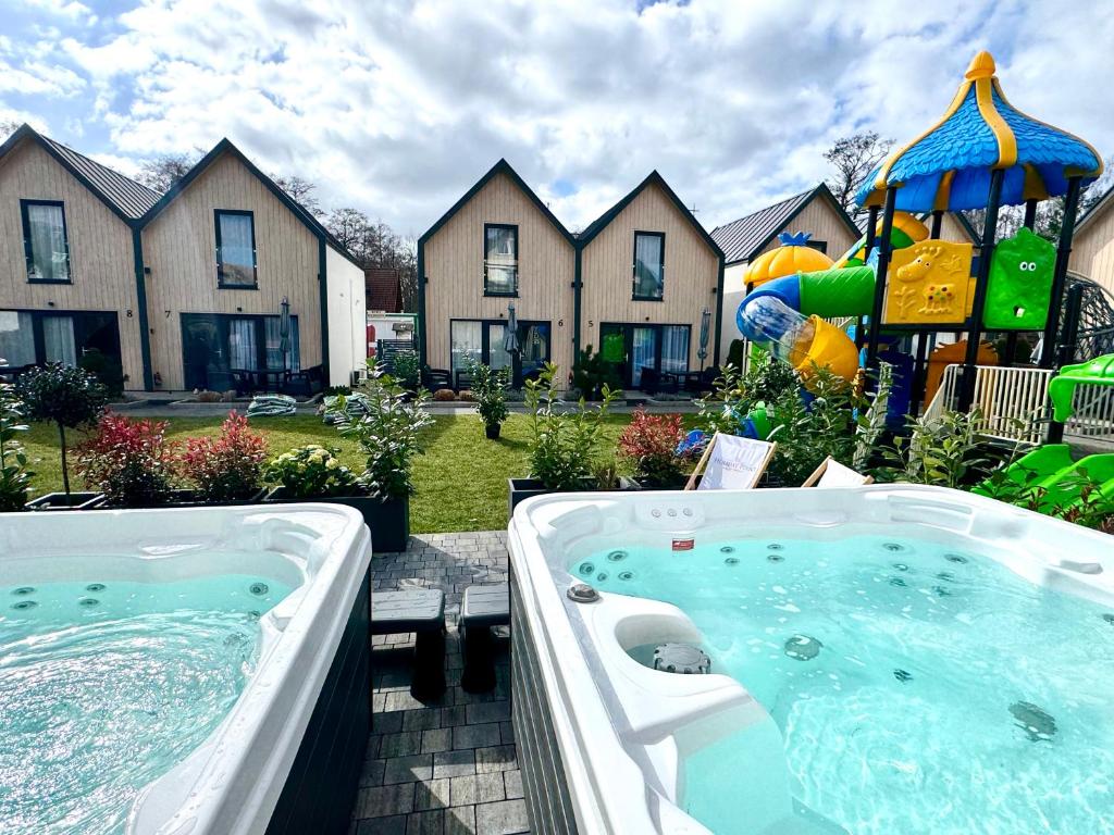 a hot tub and a playground in front of a house at Holiday Point in Międzywodzie